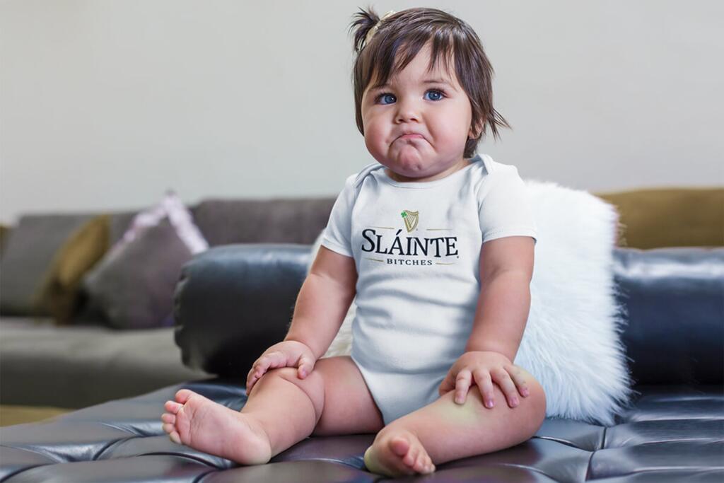 Funny female toddler wearing a white tshirt with  SLÁINTE BITCTHES designs by © 2021 funnydrinking.com