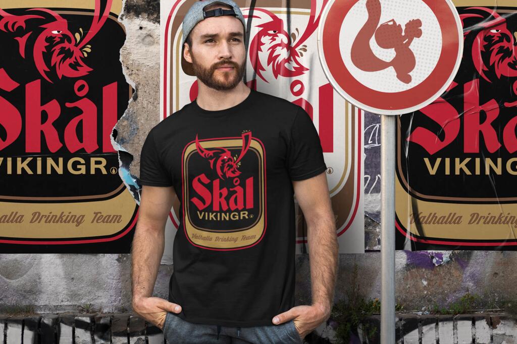 Young man wearing a black t-shirt with SKÅL VIKINGR design by funnydrinking.com